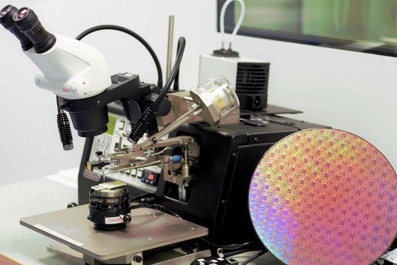 Wire bonder machine next to a full 10-inch processed wafer